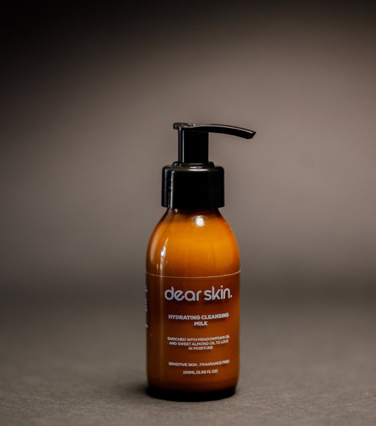 Dear Skin Hydrating Cleansing Milk in a 100ml amber pump bottle, formulated with meadowfoam and sweet almond oil to cleanse and moisturize sensitive skin.
